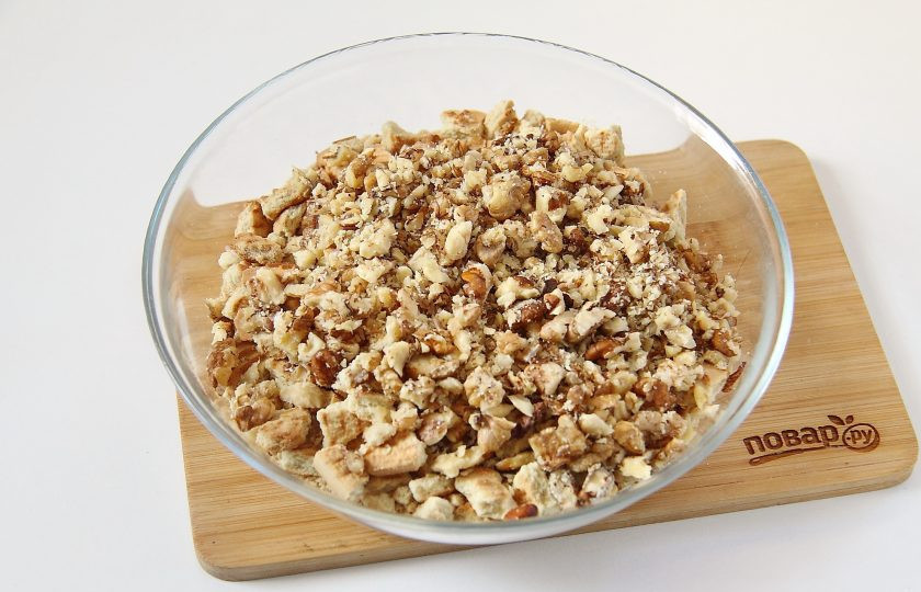 1. Этап. Кондитерская колбаска из печенья: 4. Добавьте к измельченному печенью грецкие орехи. Орехи предварительно обжарьте на сухой сковороде и порубите ножом.