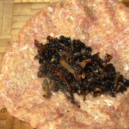 1. Этап. Свиные зразы: Из получившегося фарша формируем лепешку, в центр выкладываем немного обжаренных в растительном масле шампиньонов.