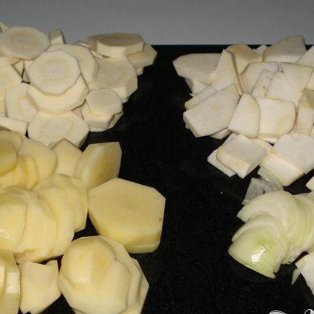 1. Этап. Выпечка из сыра и картофеля: Очистить картофель, сельдерей и пастернак и порезать их на кусочки около ½ см. Очистить и тонко нарезать ломтиками одну луковицу.