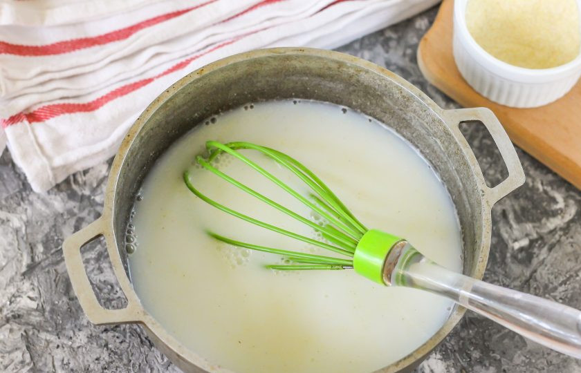 1. Этап. Кукурузная каша для грудничка: Вмешайте муку в жидкость с помощью венчика.