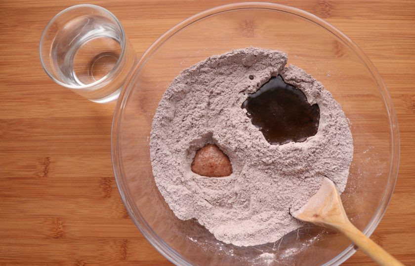 1. Этап. Постный шоколадный пирог: В этой смеси сделайте два углубления: поменьше и побольше. В меньшее углубление влейте уксус, а в большее - растительное масло без запаха. Залейте эту смесь водой и перемешайте до однородного состояния.