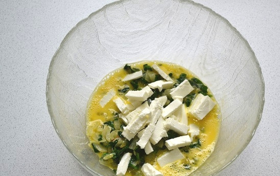 1. Этап. Пирог с фетой и шпинатом: Добавьте фету, поперчите по вкусу, перемешайте до однородности.