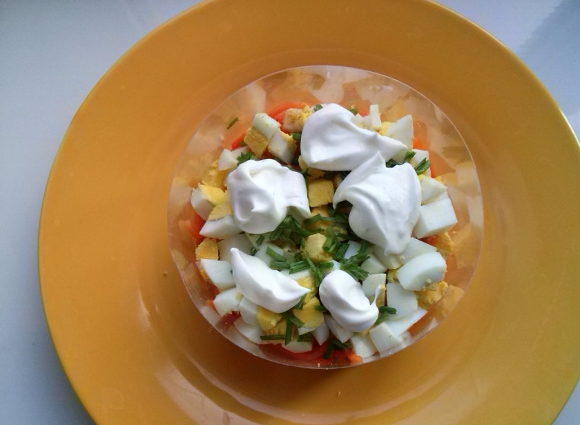 1. Этап. Салат с корейской морковкой: 3-й слой: нарежьте кубиками яйцо, затем — зеленый лук. Йогурт посолите по вкусу и выложите на салат.