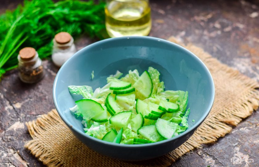 1. Этап. Салат с пекинской капустой, крабовыми палочками и кальмарами: Огурец сполосните и просушите, нарежьте небольшими полосками или кубиками, добавьте к капусте.