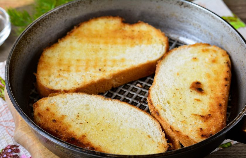 1. Этап. Гренки с крабовыми палочками: Нарезанные кусочки батона обжарьте с двух сторон на сухой сковороде.