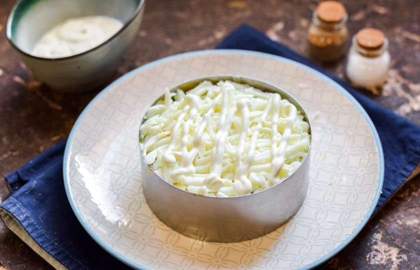 1. Этап. Мимоза с консервой: Куриные яйца очистите, разделите белки и желтки. Белки натрите на средней терке и посыпьте салат.