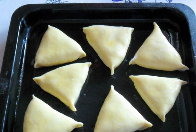 1. Этап. Тесто для самсы на кефире: 8. Слепить треугольники, которые выложить на смазанный маслом противень швом вниз. Смазать взбитым яйцом. Отправить в разогретую духовку и выпекать около 25-35 минут до готовности.