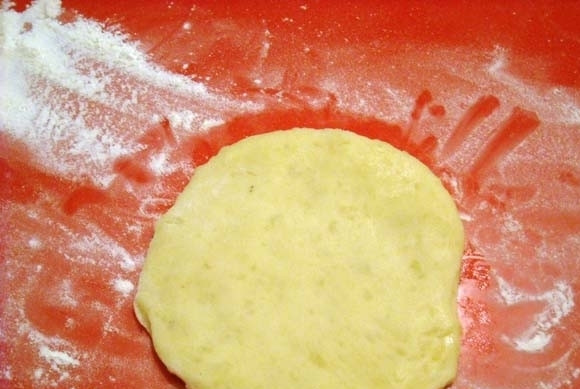 1. Этап. Картофельные шарики с начинкой: Из картофельного теста отщипните кусочек, примерно, в 75 грамм. Сделайте лепёшку в 4 мм толщиной.