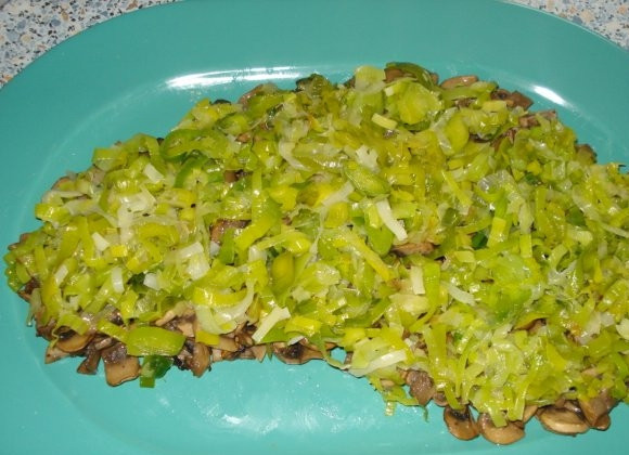 1. Этап. Салат Золотая лошадь: Уложите грибы на тарелку, в которой и будете подавать салат, в форме лошадиной головы. Для этого можете воспользоваться трафаретом. Мелко порубите лук-порей, немного потушите его под закрытой крышкой и уложите сверху грибов.