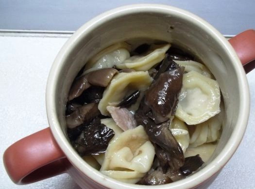 1. Этап. Пельмени, запеченные с грибами: Затем сложите пельмени и грибы в горшочек, перемешайте.