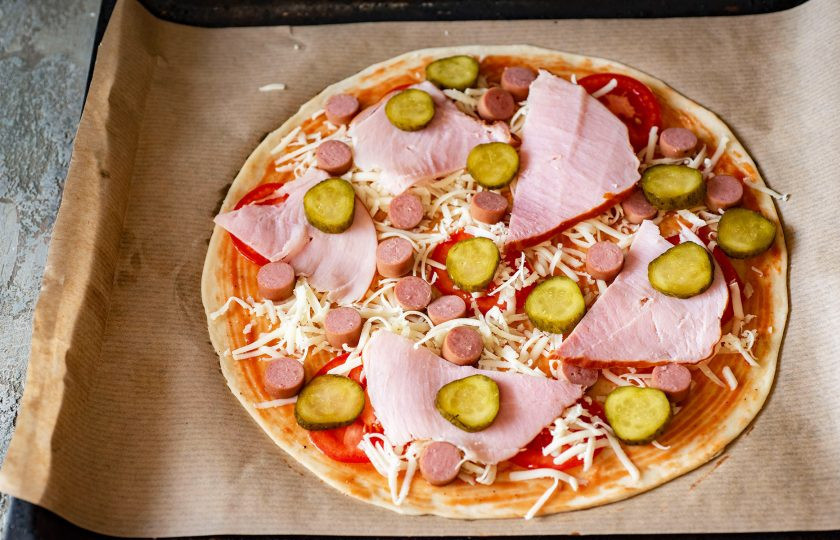 1. Этап. Пицца Виктория: Распределите поверх тонкие ломтики ветчины и тонкие кружочки маринованного огурчика.