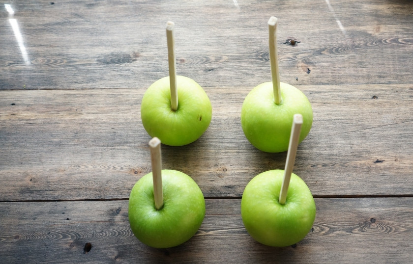 1. Этап. Карамельное яблоко: Яблоки вымойте и вытрите насухо бумажным полотенцем. Проткните их палочками. Можно использовать одноразовые для китайской еды. Сорт яблок выбирайте на свое усмотрение, лучше, если они будут кисло-сладкими. К примеру, подойдет сорт 