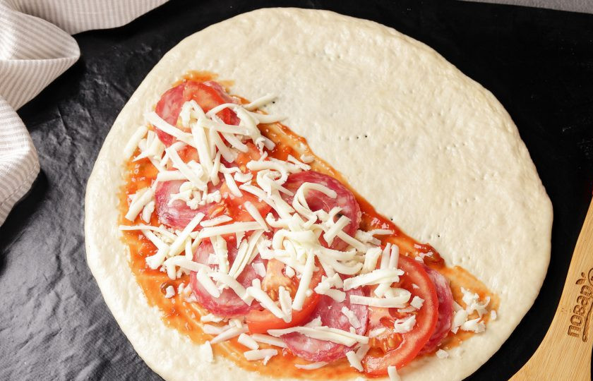 1. Этап. Пицца Кальцоне: Посыпьте начинку оставшимся сыром.