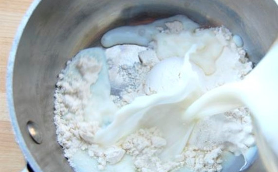 1. Этап. Молочный крем: В сотейник всыпьте муку, поставьте на средний огонь и начните постепенно вводить молоко, взбивая все венчиком.