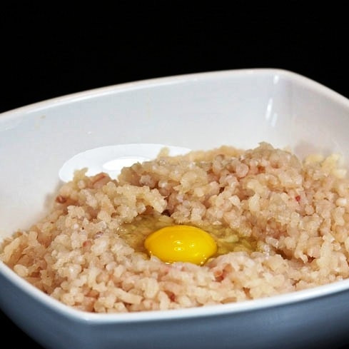 1. Этап. Рыбные котлеты с рисом: Добавляем в фарш яйцо.