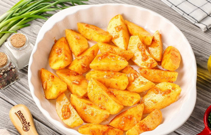 1. Этап. Картофельные дольки с сыром в духовке: Хорошо перемешайте и выложите в жаропрочную форму, а чтобы картошка пропеклась в духовке равномерно, выкладывайте её в один ряд.