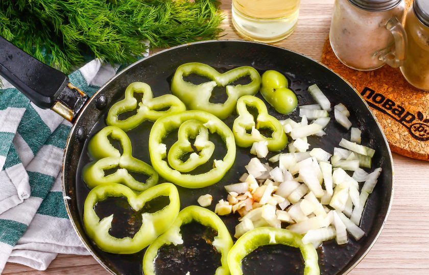 1. Этап. Рыба по-турецки: На масле, оставшемся от жарки рыбы, поджарьте кружочки перца, лук и чеснок примерно 3-4 минуты.