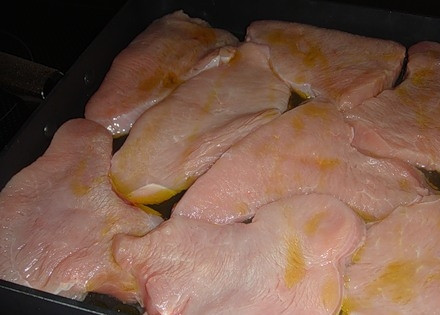 1. Этап. Индейка в сметанном соусе в духовке: Филе индейки нарезаем на куски толщиной 1 см. Смазываем их растительным маслом и выкладываем на противень.