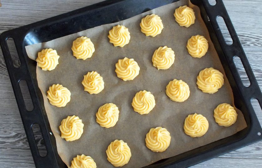 1. Этап. Профитроли с кремом Пломбир: Возьмите противень, застелите пекарской бумагой. На расстоянии друг от друга, отсадите небольшие булочки. Поставьте в разогретую до 180 градусов духовку на 25-30 минут.