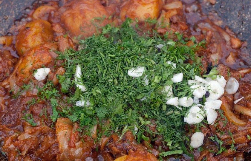 1. Этап. Картофель, тушенный со свининой и овощами: Положите в казан мясо, жарьте 10 минут. После этого положите к мясу лук и морковь. Жарьте мясо с овощами еще минут 5. Добавьте капусту, жарьте, пока капуста не станет мягкой. После того как капуста почти приготовится, налейте в казан стакан или два воды и готовьте ещё 10 минут. Когда пройдет время, переложите в казан к мясу и овощам поджаренную картошку и томите всё под крышкой еще 10-15 минут. Посолите и поперчите блюдо, добавьте немного чеснока и свежей зелени. Картофель, тушенный со свининой и овощами, готов.