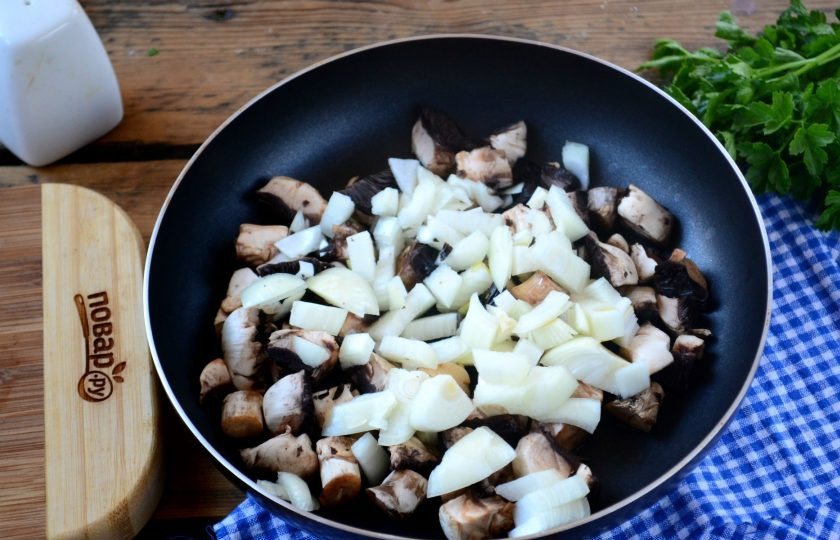 1. Этап. Охотничьи колбаски с картофелем и шампиньонами в горшочках: Лук мелко порубите. Шампиньоны порежьте небольшими кусочками. Обжарьте грибы вместе с луком на большом огне до румяности.