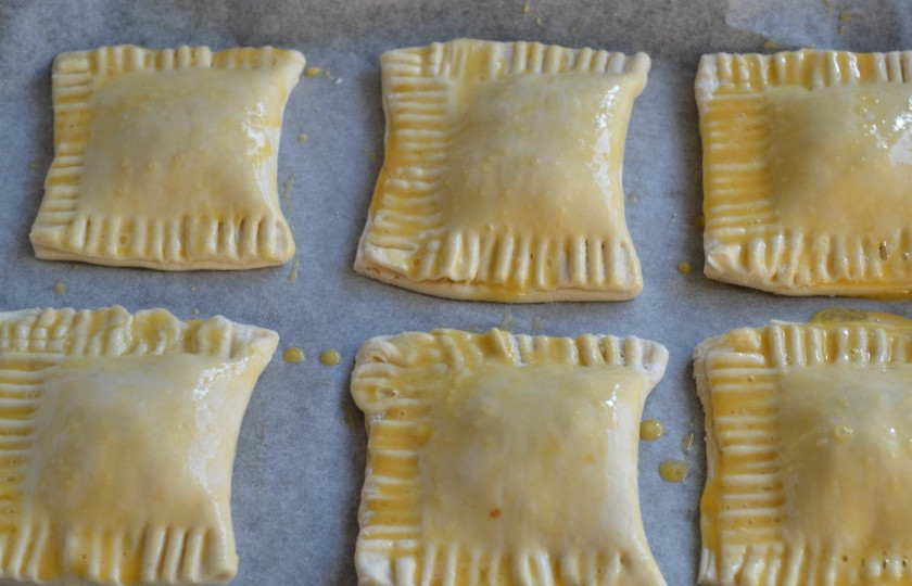 1. Этап. Слойки с вареньем из слоеного теста: Выложите слойки на противень, застеленный пергаментом, смажьте взбитым яйцом. Запекайте слойки в духовке 20 минут.