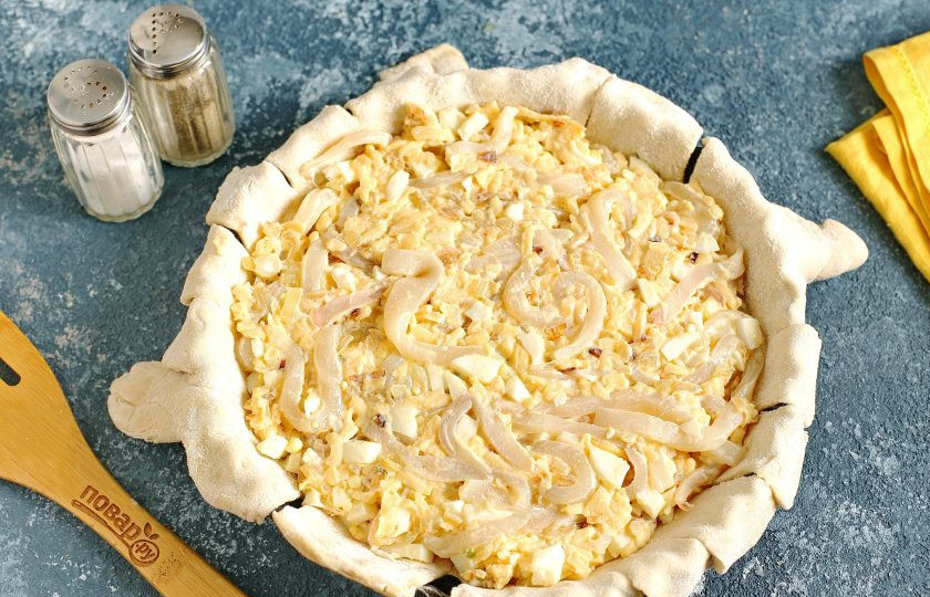 1. Этап. Пирог с кальмарами: Тесто раскатайте (чтобы оно было больше размеров формы), аккуратно перенесите и концы нарежьте кухонными ножницами на полоски. Сверху распределите равномерно начинку. Форму смазываем растительным маслом.