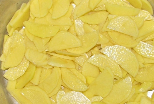 1. Этап. Скумбрия в духовке с картофелем: Выкладываем картофель на дно формы и посыпаем солью.