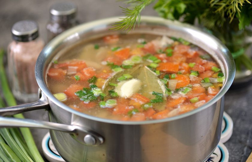 1. Этап. Уха из замороженной рыбы: Верните рыбу в сотейник, добавьте лавровый лист и раздавленный зубчик чеснока, посолите и поперчите бульон по вкусу. Варите еще минут 5 на тихом огне.