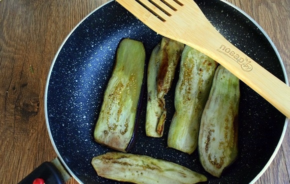 1. Этап. Баклажаны по-французски в духовке: Баклажаны разрежьте вдоль на полоски по 0,5 см толщиной, посолите с двух сторон. В сковороде разогрейте масло и обжарьте ломтики баклажанов с двух сторон по 1 минуте.