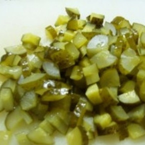 1. Этап. Солянка в мультиварке: Пока овощи жарятся, нарежьте кубиками соленые огурцы.