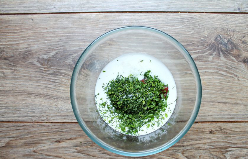 1. Этап. Соус из простокваши с томатной пастой: Зелень мелко порежьте и добавьте к простокваше. Все хорошо перемешайте и при необходимости посолите.