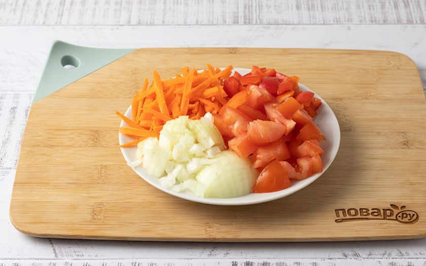 1. Этап. Булгур с овощами на плите: Морковь очистите и порежьте соломкой, а репчатый лук, помидоры и болгарский перец кубиками среднего размера.