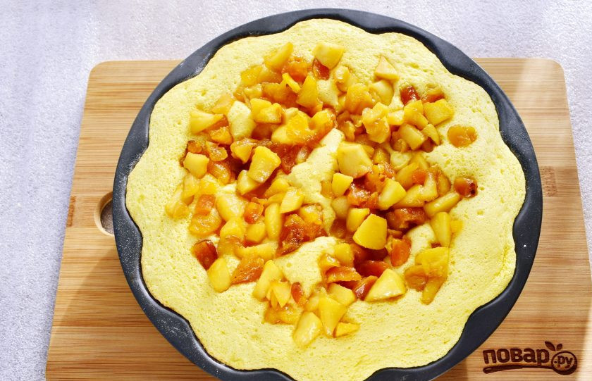 1. Этап. Шарлотка с курагой и яблоками: Затем выложите оставшиеся фрукты поверх теста и продолжайте выпекать до готовности пирога. Готовность проверяйте с помощью зубочистки, она должна выйти из теста сухой.