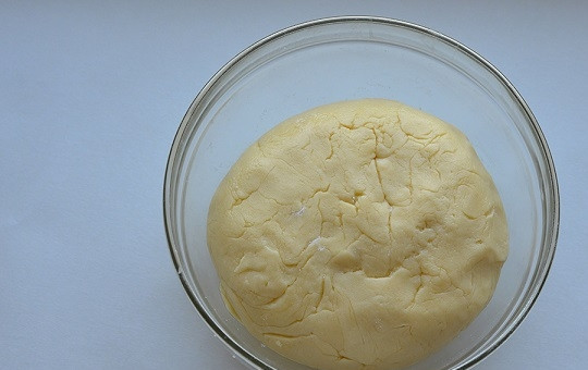 1. Этап. Творожно-сметанный торт: 3. Для аромата всыпьте щепотку ванилина и постепенно добавляйте просеянную муку, замешивая тесто. Оно должно получиться мягким, но не должно липнуть к рукам. Скатайте его в шарик, заверните в пленку и уберите в холодильник минут на 45-55.