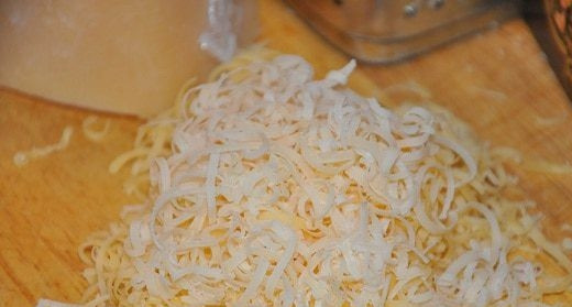 1. Этап. Ньёки: Натрите на терке твердый сыр. Вы можете использовать любые сорта сыра, в том числе пикантные, если хотите придать ньекам особый вкус и аромат. Добавьте тертый сыр в картофель.