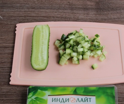 1. Этап. Праздничная закуска в тортилье: Нарежьте маленькими кубиками огурец.