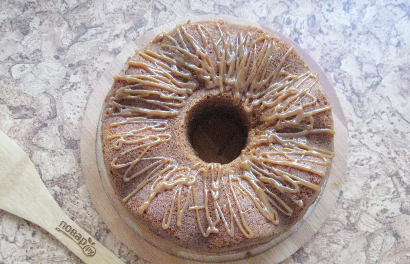 1. Этап. Кекс Сникерс: Готовый кекс охладите и достаньте из формы. В отложенное сгущенное молоко добавьте 2 столовые ложки молока и перемешайте до консистенции крема. С помощью кулинарного мешка нанесите на кекс.