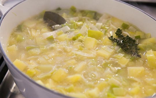 1. Этап. Картофельный суп с луком: Добавляем картофель к луку, заливаем бульоном. Если нет бульона, можно залить водой, но потом добавить к супу сливки. Солим и добавляем лавровый лист и тимьян.