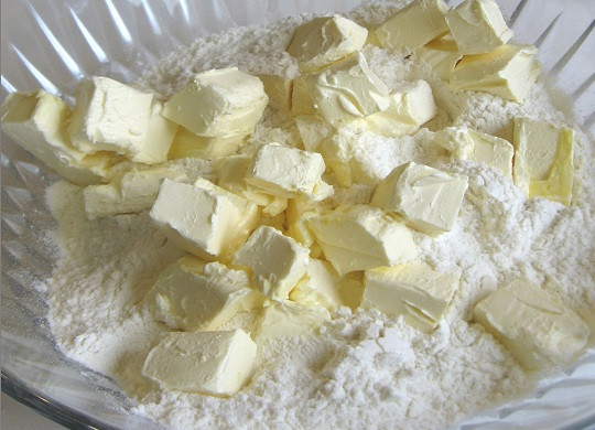 1. Этап. Пирог на маргарине с вареньем: 1. Маргарин нужно достать из холодильника заранее, чтобы он не был слишком замороженным. Нарезать его небольшими кубиками и выложить в глубокую мисочку вместе с мукой. Руками разминать массу, пока не получится однородная крошка.
