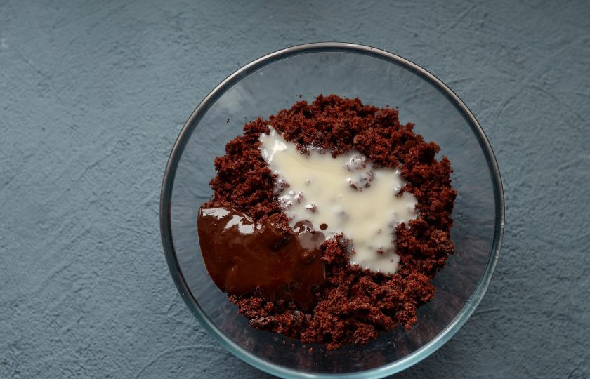 1. Этап. Веганское пирожное Картошка: Когда корж полностью остынет, раскрошите его. Добавьте в миску кокосовую сгущенку и разведённый в воде кэроб.