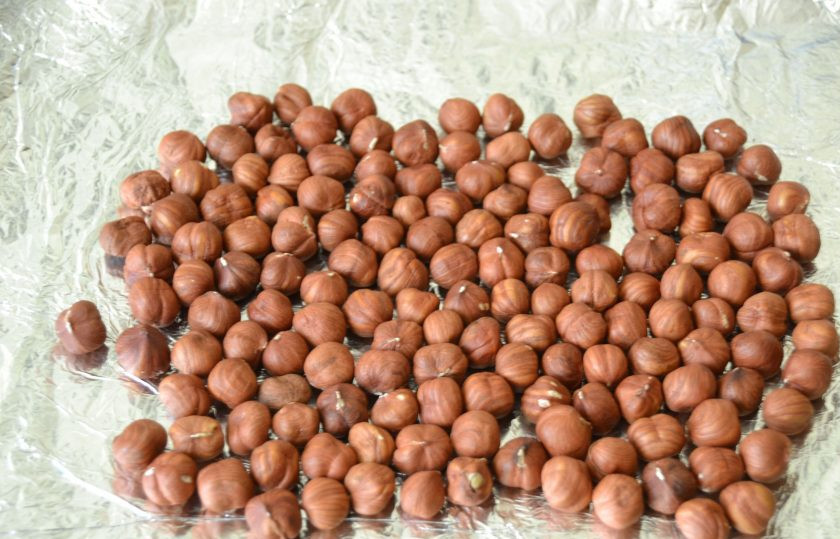 1. Этап. Дакуаз: Выложите фундук на фольгу или на бумагу для выпечки, разогрейте духовку на 150 градусов и поместите в неё орехи на 10 минут.