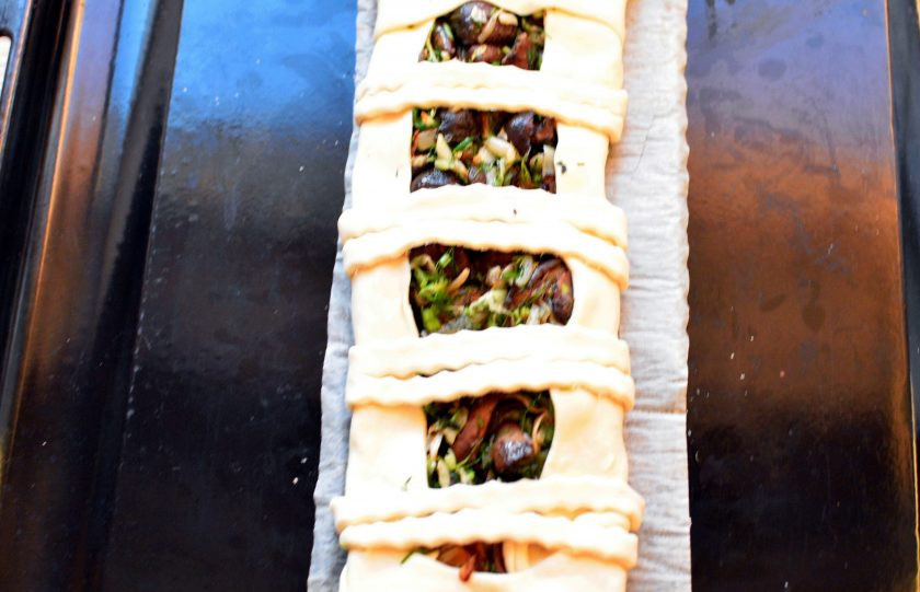 1. Этап. Быстрый пирог с маслятами: Тесто разморозьте, при необходимости раскатайте. На середину выложите начинку и сформируйте пирог. Удобно делать такие пироги в виде плетенки. У меня тесто было в узком рулоне, поэтому я сформовала просто – подогнула края со всех сторон, срезала излишки, раскатала остатки и вырезала полоски, которыми скрепила края пирога. Смажьте пирог желтком и посыпьте кунжутом.