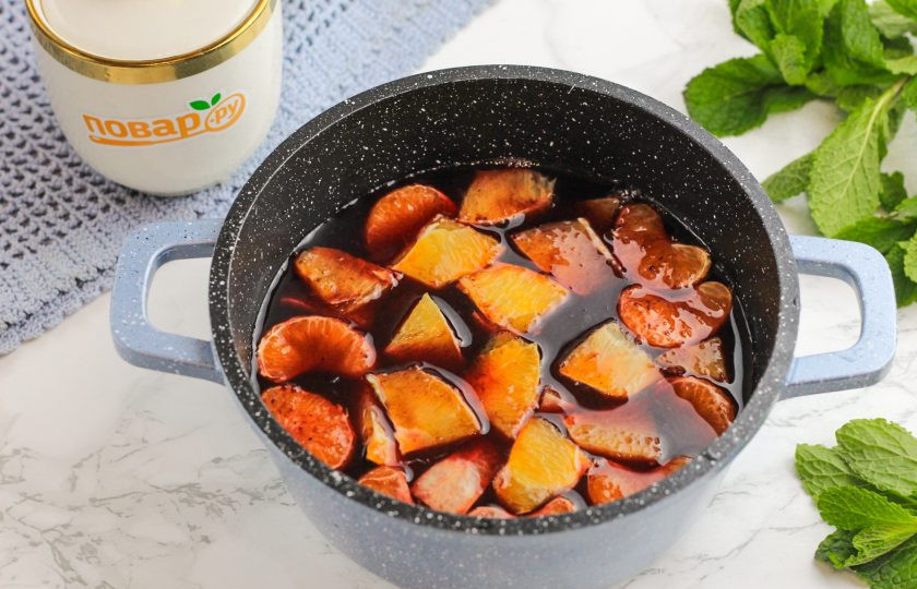 1. Этап. Черный глинтвейн: Влейте сок черной смородины в казан или кастрюлю. Очистите от кожуры мандарины и удалите белые ворсистые нити. Отделите дольки и добавьте в емкость. Апельсин очистите и удалите белый слой, нарежьте на кусочки дольки и добавьте в сок.