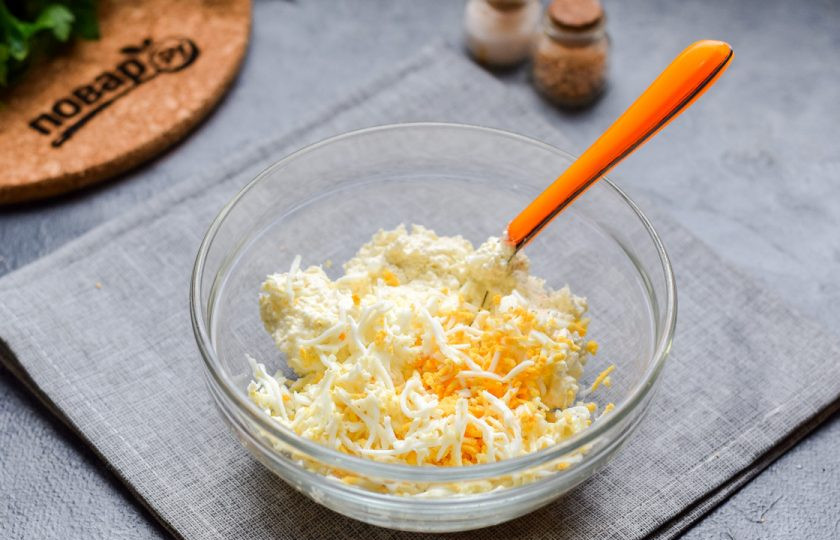 1. Этап. Болгарские рулетики: Для начинки переложите в миску творожный сыр. Вареные куриные яйца очистите и натрите на мелкой терке, добавьте к сыру.