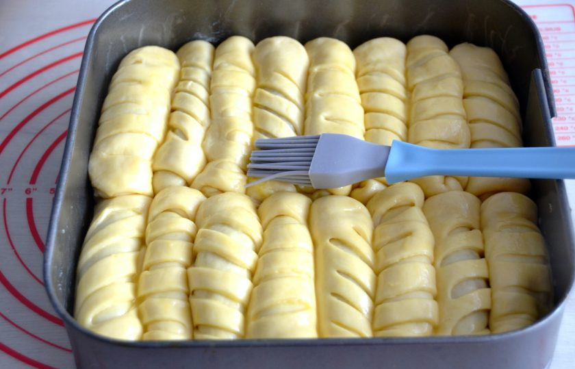 1. Этап. Пирог из рулетиков с разными начинками: Смажьте форму для запекания сливочным маслом, выложите рулетики, чередуя их в любом порядке. Благодаря разным надрезам, вы знаете, где какая начинка. Смажьте пирог смесью из яичного желтка и двух чайных ложек молока.