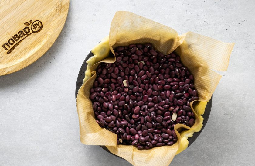 1. Этап. Вегетарианский пирог с вишней: Накройте пергаментом для выпечки, заполните пирог фасолью и выпекайте в разогретой до 180 градусов духовке 10 минут.