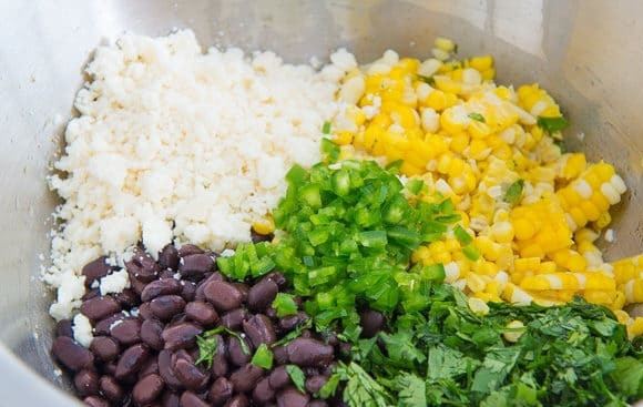 1. Этап. Мексиканский салат из кукурузы и фасоли: 2. Теперь мелко нашинкуйте кинзу и перец. Затем смешайте их с фасолью и кукурузой. Также добавьте рассыпчатый сыр.
