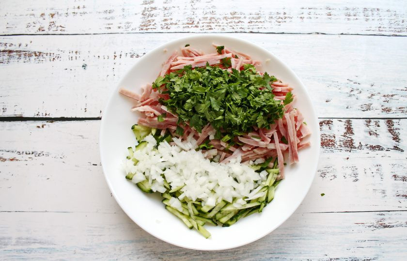 1. Этап. Салат Острые чувства: Зелень мелко порежьте и добавьте в салат. Репчатый лук мелко порежьте, обдайте кипятком и добавьте в салатник.