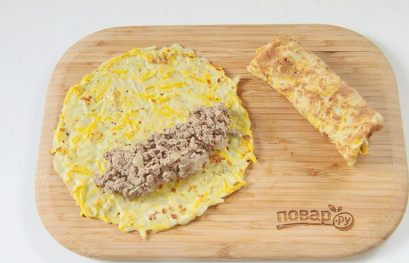 1. Этап. Тыквенные рулетики с печенью: Положите на тыквенную лепешку начинку из печени, подверните края и сверните рулетик.